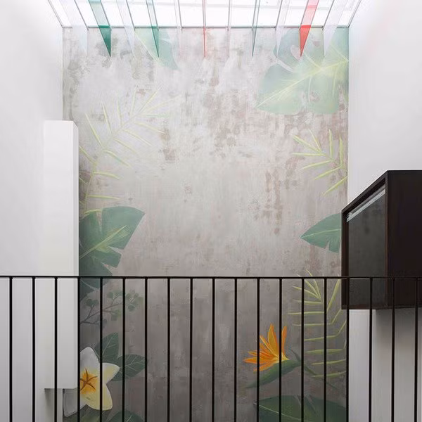 Giếng trời của nhà phố đẹp này được tô điểm bằng hệ kính màu cho hiệu ứng ánh sáng tuyệt vời. Ngoài ra, bức bích họa trên tường cũng làm nên điểm nhấn hoàn mĩ cho khu vực giếng trời.