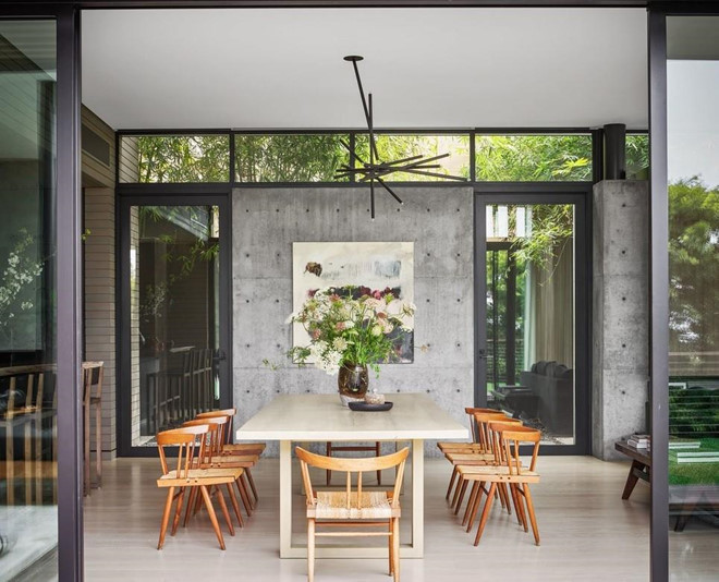 Phòng ăn thoáng mát, trang nhã, được kết nối trực tiếp với khu vực ngoài trời, có điểm nhấn là chiếc đèn chùm mang hình thù kỳ lạ.