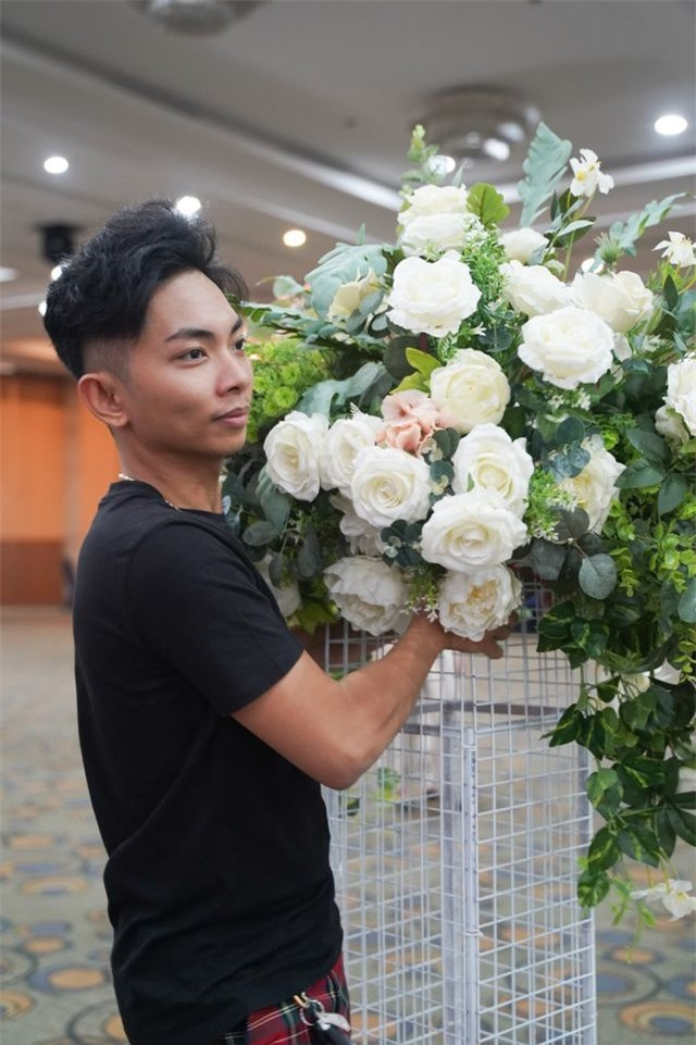 Trước buổi tiệc, vợ chồng Khánh Thi - Phan Hiển tất bật đến địa điểm diễn ra giải đấu để cùng mọi người trang trí, sắp xếp không gian. Trong khi bà xã để mặt mộc, ăn mặc giản dị cùng điểm lại danh sách thí sinh và số báo danh, Phan Hiển không ngại bưng hoa.