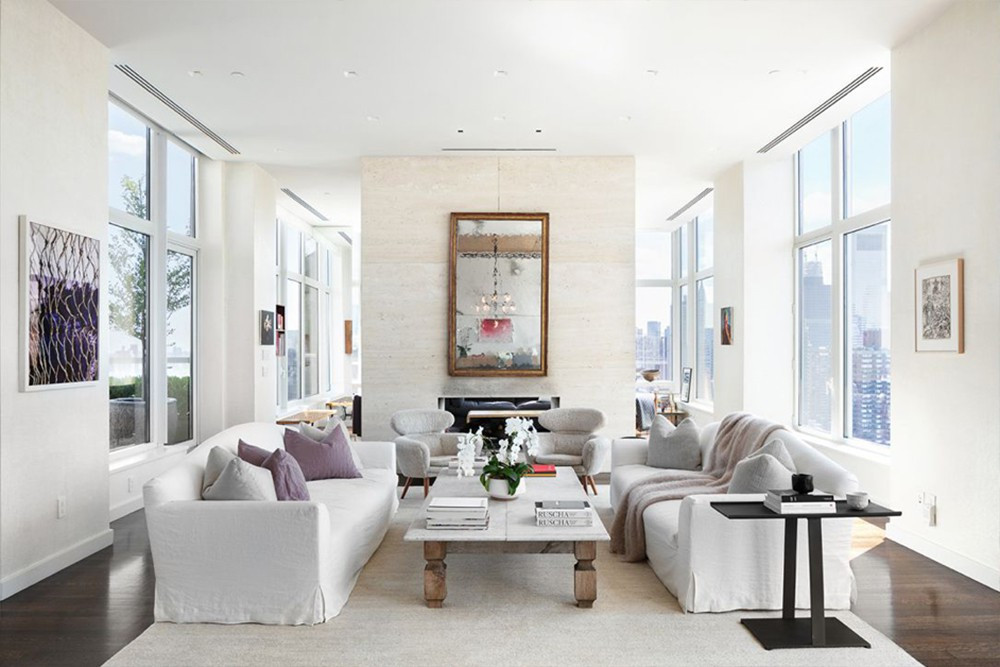 Phía trong căn hộ được thiết kế theo phong cách cởi mở, thoáng đãng với những ô cửa kính xung quanh cùng trần nhà cao hơn 3,6 m. Phòng khách sáng sủa với các nội thất mang tông màu trắng nhẹ nhàng.