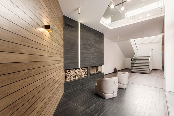 Đa dạng các nguyên vật liệu thiết kế giúp ngôi nhà nổi bật nhất có thể Gỗ là vật liệu chủ yếu nhưng bên cạnh đó còn có đá granite với kết cấu tự nhiên. Các nhà thiết kế đã tạo nên vỏ ngoài của ngôi nhà làm bằng gỗ với màu nâu sáng giúp ngôi nhà trông bắt mắt đồng thời đem lại cảm giác ấm áp cho người cư ngụ. Mái nhà làm bằng thép hợp kim chất lượng cao giúp cách nhiệt giữa bên trong và bên ngoài. Các cửa sổ và cửa ra vào bằng kính lớn cung cấp tầm nhìn toàn cảnh ra khu rừng xung quanh và giúp ánh sáng tự nhiên tràn vào nhà. Tầng trên được thiết kế theo phong cách tối giản, nhấn mạnh vào không gian sống và sự liên kết giữa bên trong với môi trường bên ngoài. Vì vậy mà nội thất khu vực này khá đơn giản kết hợp cùng một bức tường kín lớn tạo không gian mở ra bên ngoài.