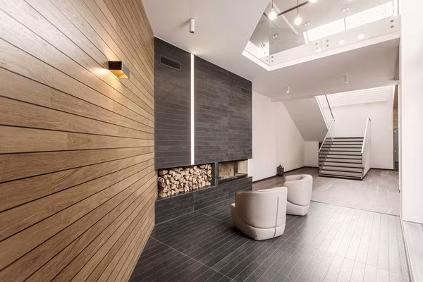 Đa dạng các nguyên vật liệu thiết kế giúp ngôi nhà nổi bật nhất có thể Gỗ là vật liệu chủ yếu nhưng bên cạnh đó còn có đá granite với kết cấu tự nhiên. Các nhà thiết kế đã tạo nên vỏ ngoài của ngôi nhà làm bằng gỗ với màu nâu sáng giúp ngôi nhà trông bắt mắt đồng thời đem lại cảm giác ấm áp cho người cư ngụ. Mái nhà làm bằng thép hợp kim chất lượng cao giúp cách nhiệt giữa bên trong và bên ngoài. Các cửa sổ và cửa ra vào bằng kính lớn cung cấp tầm nhìn toàn cảnh ra khu rừng xung quanh và giúp ánh sáng tự nhiên tràn vào nhà. Tầng trên được thiết kế theo phong cách tối giản, nhấn mạnh vào không gian sống và sự liên kết giữa bên trong với môi trường bên ngoài. Vì vậy mà nội thất khu vực này khá đơn giản kết hợp cùng một bức tường kín lớn tạo không gian mở ra bên ngoài.