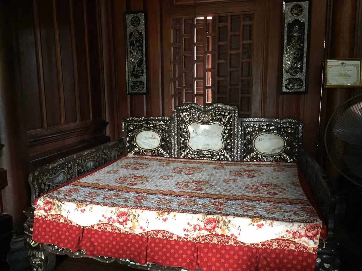 Hai gian hai bên hông của ngôi nhà ông Hạ đều kê một bộ bàn ghế làm bằng gỗ gụ để tiện cho việc đón, tiếp khách. “Ngôi nhà được thiết kế theo kiến trúc cổ nên gia đình rất ưng và thích. Ở trong ngôi nhà này mùa hè thoáng mát, còn mùa đông lại ấm”, ông Hạ nói. Chiếc giường ngủ cũng được gia chủ đặt, thiết kế đóng theo lối cổ kính. Theo chủ nhân của ngôi nhà, mất hơn nửa năm tốp thợ hơn chục người mới thi công, lắp ghép xong ngôi nhà.