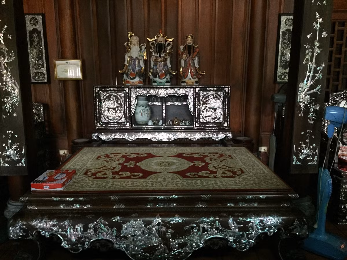 Tại khu vực bàn ngồi tiếp khách, một bức tranh được treo trang trọng. Ông Hạ cho biết, ngoài số tiền gia đình ông bỏ ra, con trai ông làm kinh doanh mỏ đá cũng hỗ trợ, bỏ ra một số tiền lớn để ông có thể hoàn thiện hai ngôi gỗ vào cùng một thời điểm. Gian giữa, ông Hạ đặt một chiếc sập làm bằng gỗ gụ. Theo lời chủ nhân, ở điểm năm 2008, ngôi nhà của ông được coi là một trong những ngôi nhà gỗ “khủng” nhất miền Bắc. Còn thời điểm hiện tại, có nhiều công trình nhà gỗ to, đắt tiền hơn nhà của ông.