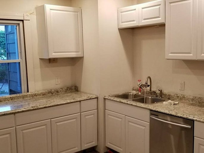 Phòng bếp sau khi sửa nổi bật với tủ bếp màu trắng, mặt bàn bằng đá cẩm thạch và các thiết bị mới. (Ảnh: Business Insider)