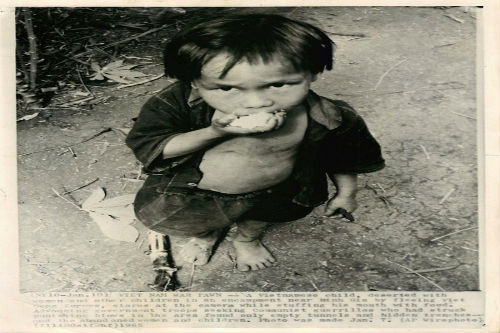 Em bé Việt Nam ăn nắm cơm trắng một cách ngấu nghiến (1965-1975). (Ảnh AP)