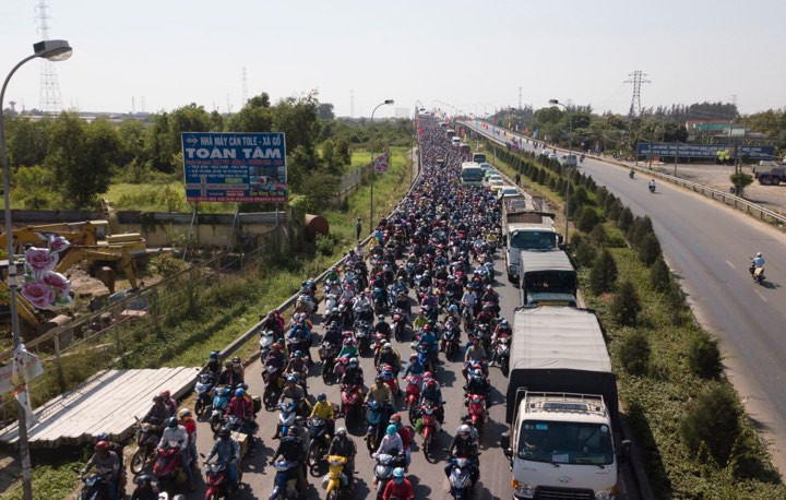 Từ giữa trưa cùng ngày, bất chấp nắng nóng gay gắt mùa khô miền Nam, hàng trăm nghìn người đi xe máy mang biển số các tỉnh miền Tây như Long An, Tiền Giang, Bến Tre, Vĩnh Long, Trà Vinh, Đồng Tháp, Hậu Giang, Cần Thơ, Sóc Trăng, Bạc Liêu, An Giang, Kiên Giang, Cà Mau vẫn ào ạt lưu thông khiến giao thông qua cầu Bến Lức về đến tận ranh giới TP HCM dài hàng chục km kẹt cứng sau kỳ nghỉ Tết dài ngày.