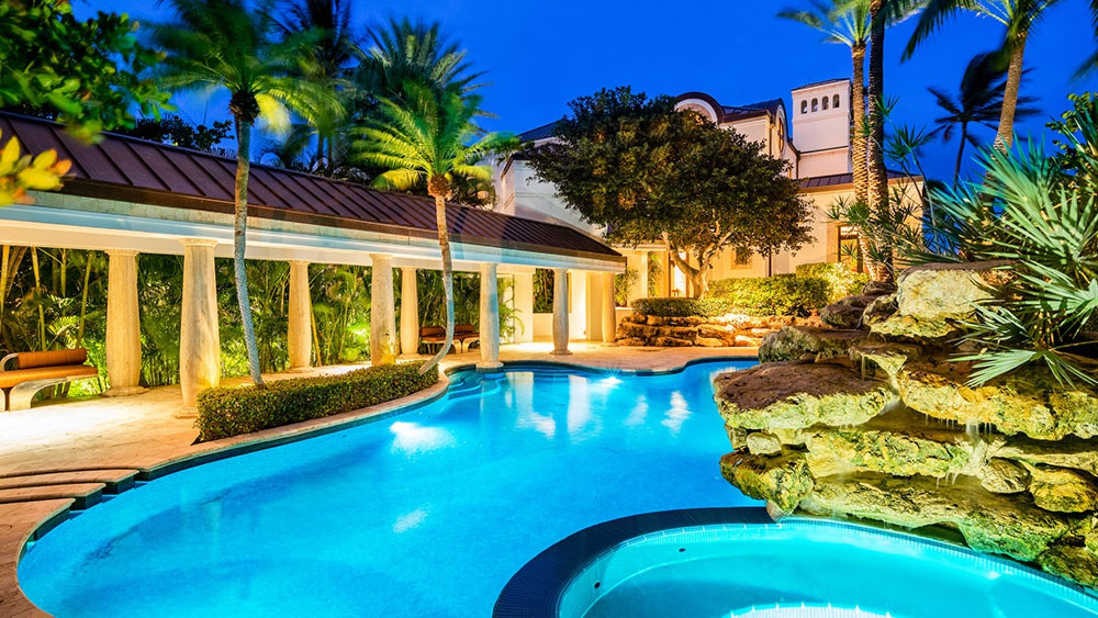 Không gian thư giãn ngoài trời với hồ bơi, bồn tắm nước nóng, khu vực spa, và khu vực nấu nướng, ăn uống.