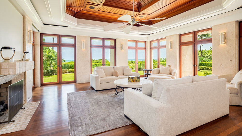 Phòng khách thoáng đãng nằm sát bên sân vườn với tông màu be trang nhã, cùng sàn gỗ, trần gỗ đem đến sự ấm cúng, gần gũi.