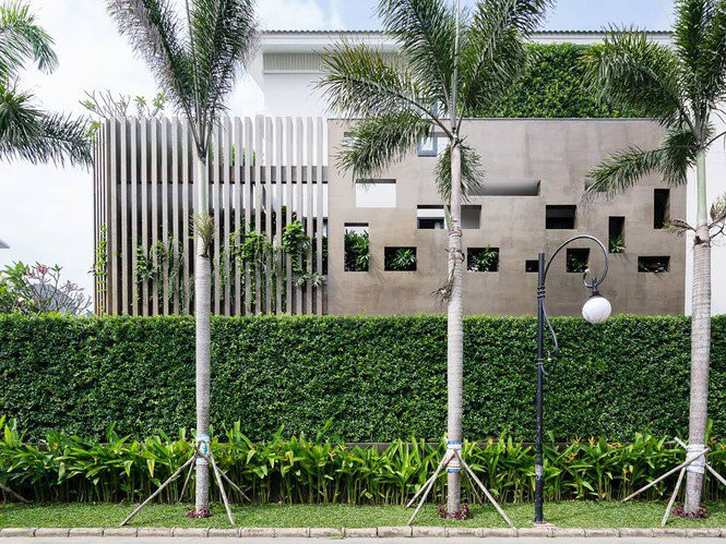 Hàng rào lớp ngoài của ngôi nhà làm từ cây xanh cắt tỉa đẹp mắt. Kế đến là hàng rào bằng tường bê tông với những khoảng hở cần thiết cho việc thông gió cho bên trong công trình.