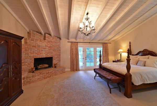 Phòng ngủ chính rộng rãi với lò sưởi và đèn chùm mang đến cảm giác lãng mạn, ấm áp. Cánh cửa mang phong cách Pháp dẫn ra ban công của biệt thự.