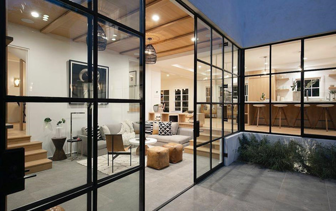 Ngôi nhà của vợ chồng Bieber có gam màu vàng mustard và xanh xám làm chủ đạo. Chất liệu gỗ được sử dụng hầu hết, từ sàn nhà, kệ trang trí đến bàn ăn. Ngôi nhà thuộc sở hữu của giọng ca Sorry trông thoáng mát hơn với cửa kính trong suốt.