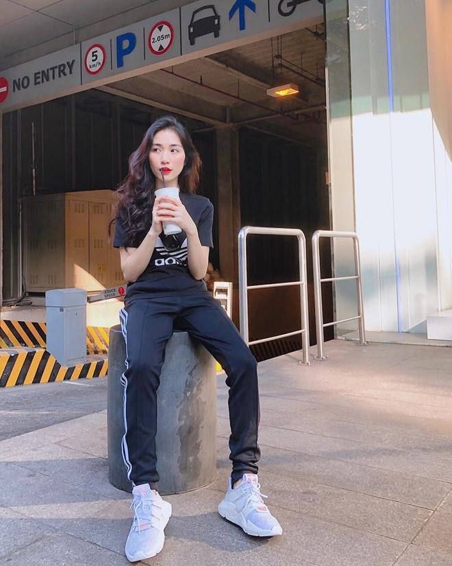 Nữ ca sĩ khoẻ khoắn với set đồ thể thao tông đen in logo của Adidas cùng sneakers trắng năng động.