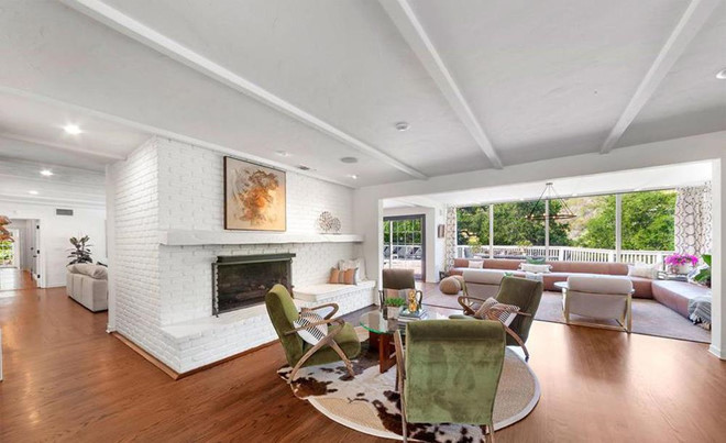 Với lò sưởi cỡ lớn là trung tâm, phòng khách có nhiều khu vực để trò chuyện, ăn uống cùng nội thất đa dạng.