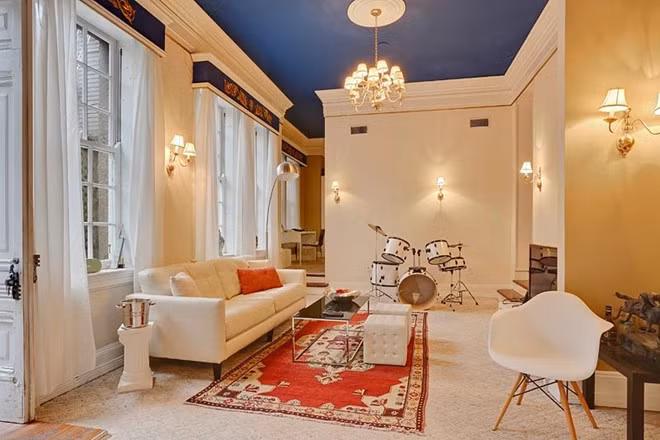 Một phòng khách nhỏ nhắn với vẻ đẹp trang nhã, nhẹ nhàng từ các bức tường màu kem và trần nhà màu xanh navy.