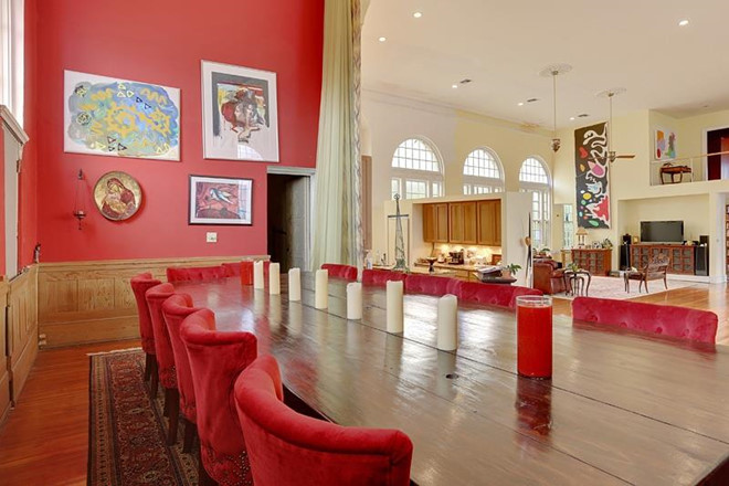 Ngay cạnh phòng khách là một khu vực ăn uống nhỏ nhắn, trang trọng với tường đỏ, bộ ghế nhung, được chia cách với các không gian khác bởi tấm rèm mềm mại.