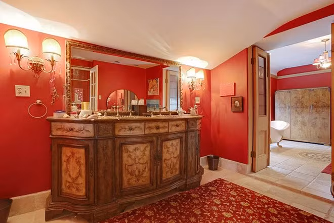 Cũng như phòng ngủ chính, phòng tắm chính mang tông màu đỏ chủ đạo, được chia thành nhiều khu vực tách biệt. Điểm nhấn ở đây là chiếc bàn trang điểm cầu kỳ rất thích hợp với những ngôi sao âm nhạc.