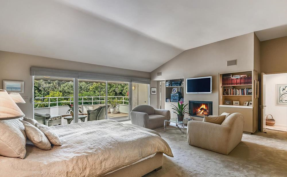 Phòng ngủ chính nằm riêng tư trên tầng 2, với không gian được kết hợp cùng khu vực tiếp khách, lò sưởi, phòng chứa quần áo, và ban công rộng rãi. Ảnh: Douglas Elliman.