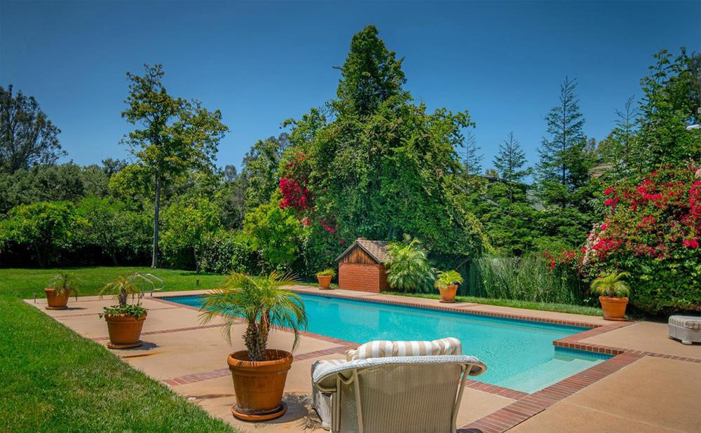 Bể bơi ngoài trời trong khuôn viên biệt thự. Ảnh: Douglas Elliman.