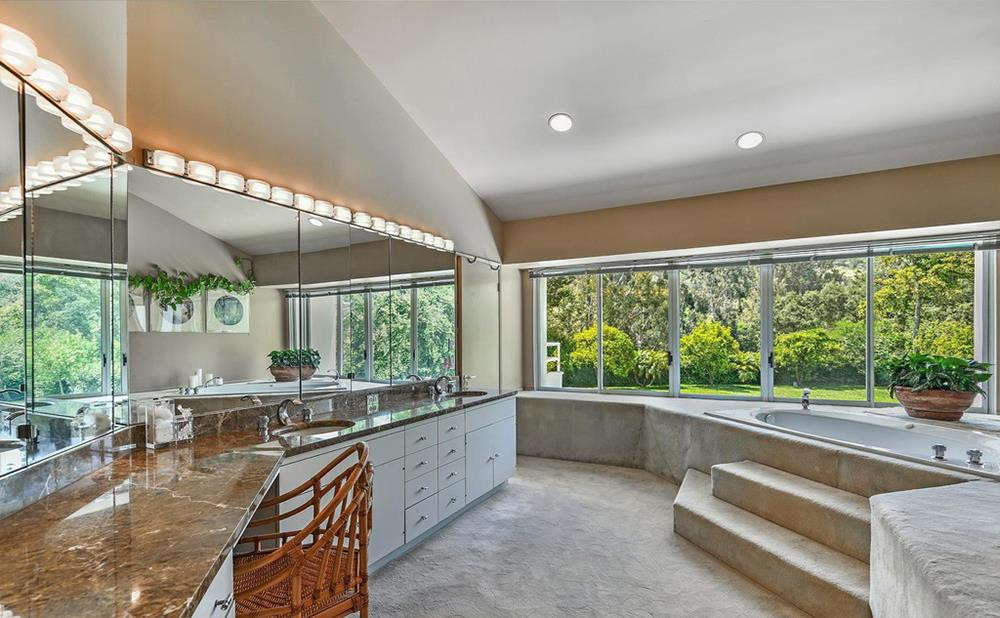 Phòng tắm được trải thảm và có góc nhìn ra bãi cỏ nơi sân vườn. Ảnh: Douglas Elliman.