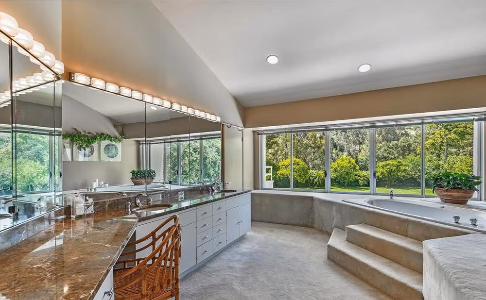 Phòng tắm được trải thảm và có góc nhìn ra bãi cỏ nơi sân vườn. Ảnh: Douglas Elliman.