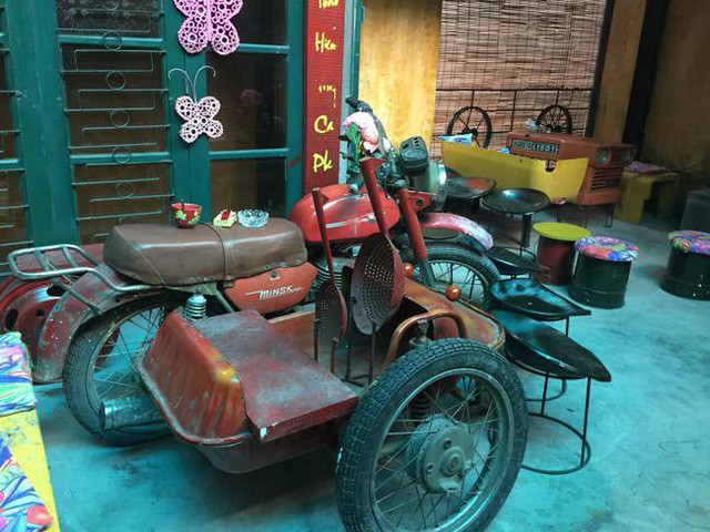 Chiếc xe gắn máy Milk của Nga đã bị hư hỏng được chủ quán tận dụng vừa làm bàn ngồi vừa làm đồ trang trí.