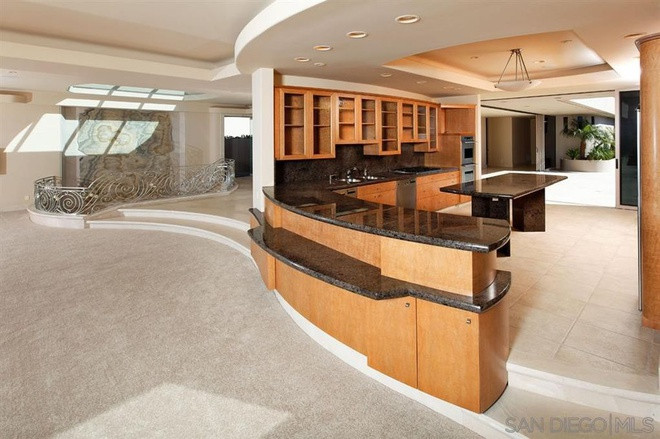 Không gian nhà bếp được thiết kế cởi mở, rộng rãi với những gam màu nóng đem lại sự ấm áp, gần gũi. Những chiếc tủ gỗ cỡ lớn và các bàn đá màu đen tăng thêm nét sáng sang trọng cho căn phòng.