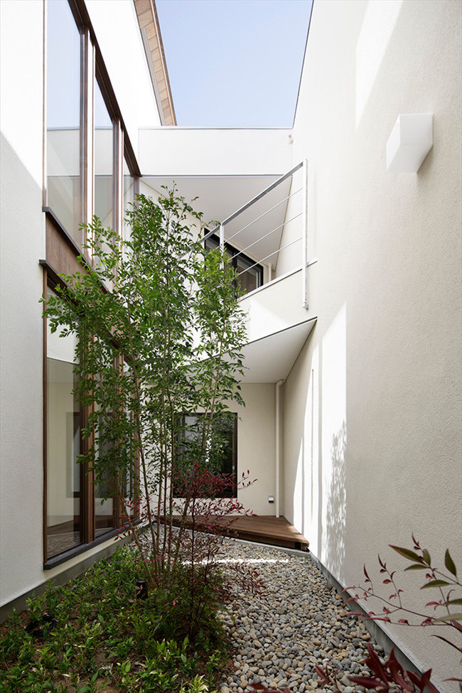 Giếng trời lớn giúp lấy sáng và thông gió được trồng thêm cây xanh. Tường gạch màu trắng vốn được nhiều người lựa chọn vì chúng vừa tự nhiên nhưng vẫn rất sang trọng.