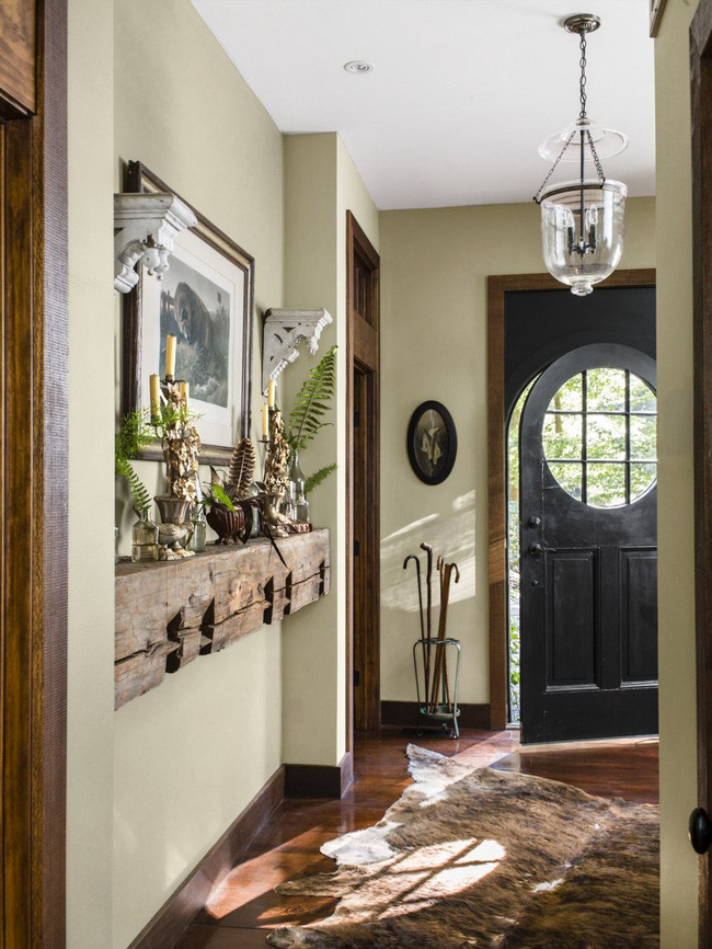 Khu vực cửa ra vào ấn tượng với thảm trải kỳ quái cùng những vật liệu trang trí trên kệ gỗ.