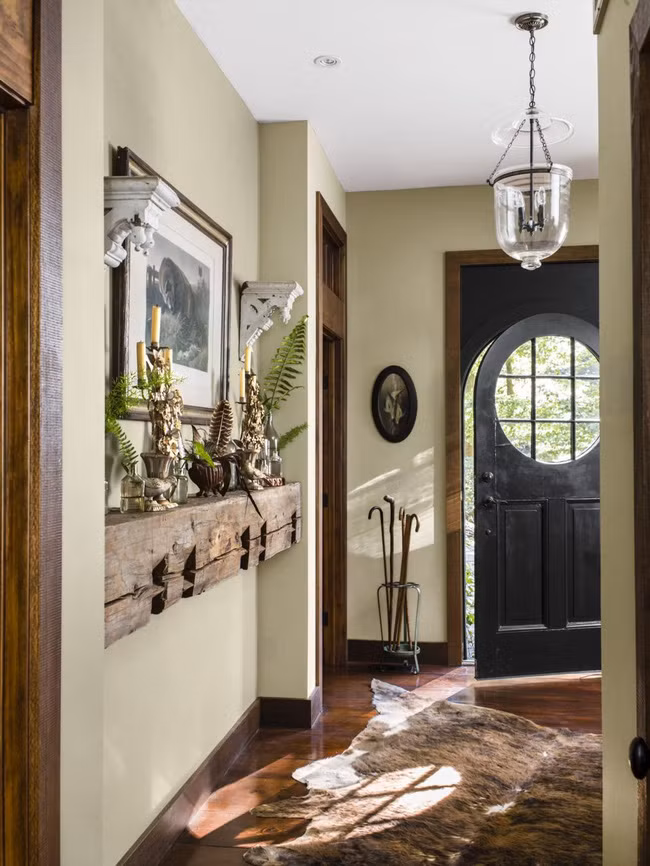 Khu vực cửa ra vào ấn tượng với thảm trải kỳ quái cùng những vật liệu trang trí trên kệ gỗ.