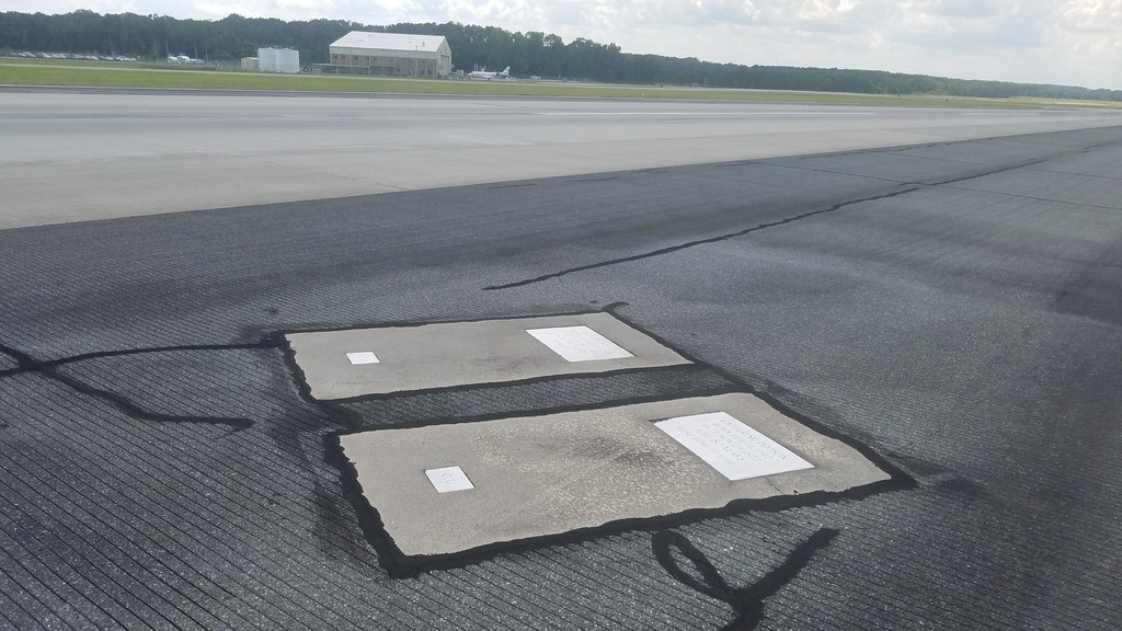 Ngày nay, các ngôi mộ nhà Dotson trông như bản vá bê tông từ việc sửa chữa hệ thống đường nhựa. Từ đây, những câu chuyện ma bắt đầu xuất hiện từ lời kể của các phi hành đoàn khi cất cánh và hạ cánh trên nắp ngôi mộ. Ảnh: Linkin.