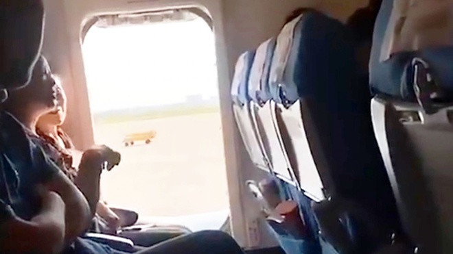 Mở cửa máy bay sắpbay: Trước khi máy bay của hãng hàng không Hạ Môn (Trung Quốc) cất cánh, một hành khách đã mở cửa thoát hiểmvì lý do cabin quá ngột ngạt. Hành vi này khiến chuyến bay bị hoãn 1 giờ. Ảnh:AsiaWire.