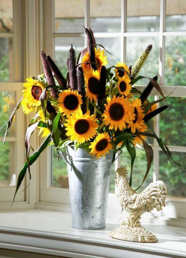 Một bình hoa hướng dương được cắm cùng cỏ và cây bồ hoàng cũng là gợi ý vô cùng thú vị giúp góc bếp thêm ấm áp và gần gũi khi đặt trang trí ở góc cửa sổ.