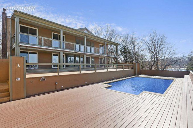 Căn biệt thự có một bể bơi ngoài trời riêng biệt, nhìn ra bờ biển dài.