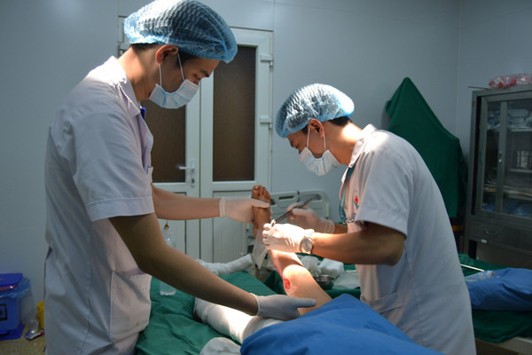 Bác sĩ làm sạch vết thương cho bệnh nhi.