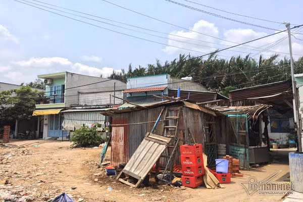 Căn phòng trọ của vợ chồng anh Dũng, 40 tuổi rộng 10 m2, giá thuê 1 triệu đồng/tháng chưa kể tiền điện nước. Anh cho biết, đã ở đây hơn 10 năm. Những ngày mưa và thủy triều dâng cao, nước đen ngòm dưới ao bên cạnh dâng lên, kèm theo rác, chất thải…tràn vào nhà, mùi hôi khó chịu. Nước rút, các chất bẩn đọng lại, ruồi muỗi bay khắp nhà. Để cải thiện, anh Dũng phải treo đồ lên cao, chắn cửa ra vào. Chỗ ngủ thì dùng gạch và thân cây kê lên.