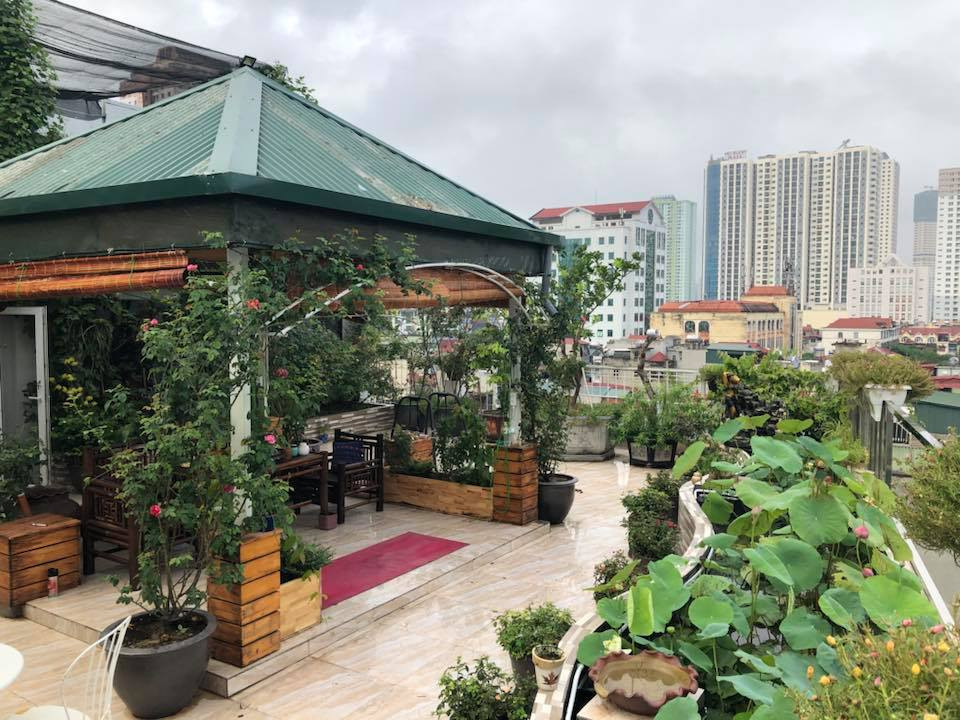 Giữa sân thượng, chị Thúy chủ thiết kế mái che đặt một bộ bàn ghế để mọi người vừa ngồi ngắm cảnh vừa thưởng trà trong mọi thời tiết. Còn gì tuyệt vời hơn khi vừa nhâm lý tách trà nóng vừa ngắm nhìn vẻ đẹp của một góc nhỏ Hà Nội từ trên cao.