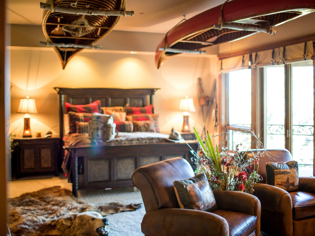Ở căn phòng ngủ này, sự xuất hiện của hai chiếc thuyền treo ngược và thảm da động vật cùng tông màu nâu trầm của giường và sofa lại mang đến cảm giác hoang dã, đậm chất thiên nhiên núi rừng.