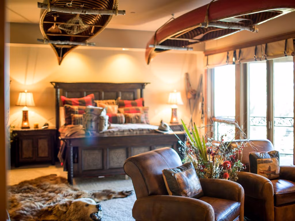 Ở căn phòng ngủ này, sự xuất hiện của hai chiếc thuyền treo ngược và thảm da động vật cùng tông màu nâu trầm của giường và sofa lại mang đến cảm giác hoang dã, đậm chất thiên nhiên núi rừng.