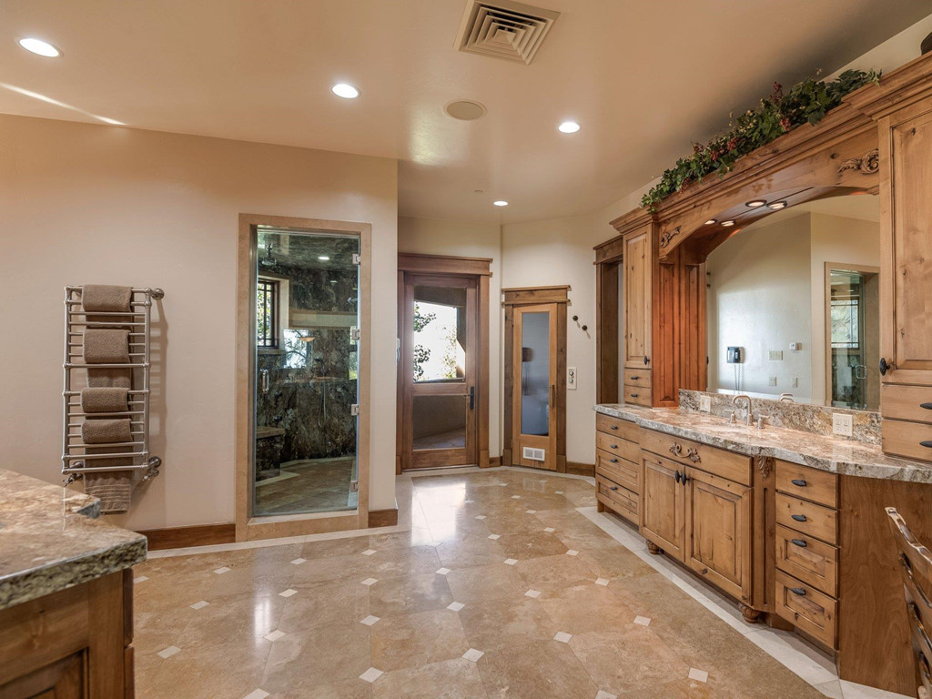 Các chi tiết trong phòng tắm hầu hết được ốp đá nâu, cùng ngôn ngữ thiết kế màu chung trong toàn bộ không gian nhà. Bên cạnh những ô cửa sổ đón ánh sáng tự nhiên từ ngoài và tạo cảm giác thư giãn, tấm gương lớn đặt chính giữa giúp không gian thêm sâu rộng.