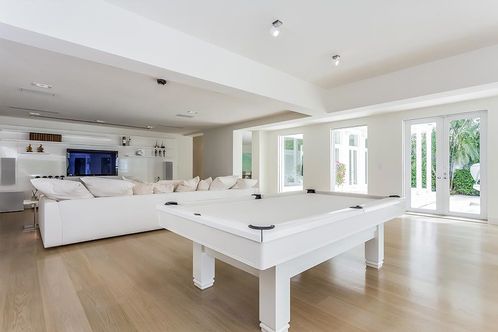 Khu vực giải trí với hệ thống máy chiếu, âm thanh cao cấp và một bàn billiard màu trắng, phù hợp với tông màu tại đây.