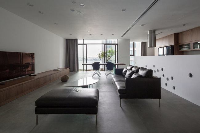 Cặp vợ chồng trẻ mua hai căn hộ với cùng diện tích là 93m2, thiết kế giống hệt nhau, nằm 2 tầng liên tiếp là 12 và 12a, trong một tòa nhà cạnh Hồ Tây. Họ đã biến 2 căn hộ tại hai tầng khác nhau thành một biệt thự 2 tầng. Tầng một là không gian sinh hoạt chung cho cả gia đình và là phòng khách của căn “biệt thự” này.