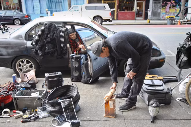 Ông Orta (bên phải) đang bán một số món đồ mình tìm được. Mục tiêu mỗi ngày của ông là 30-40 USD. Ảnh NYT