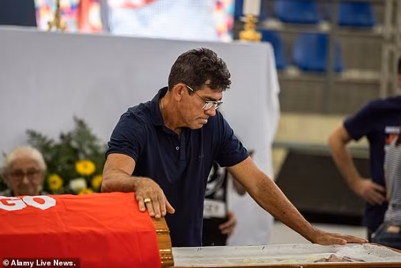 Cha của Cizinato Diniz đau lòng cúi đầu bên chiếc quan tài của con trai.