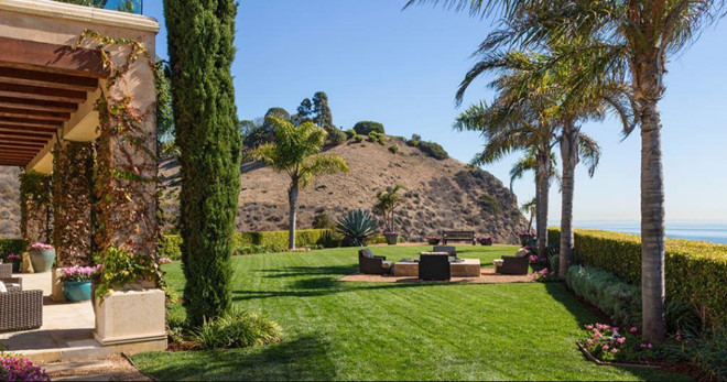 Lối vào biệt thự rộng rãi và được trang trí cầu kỳ, tỉ mỉ. Khuôn viên với bãi cỏ xanh mướt và hàng cọ trải dài dọc bờ biển.