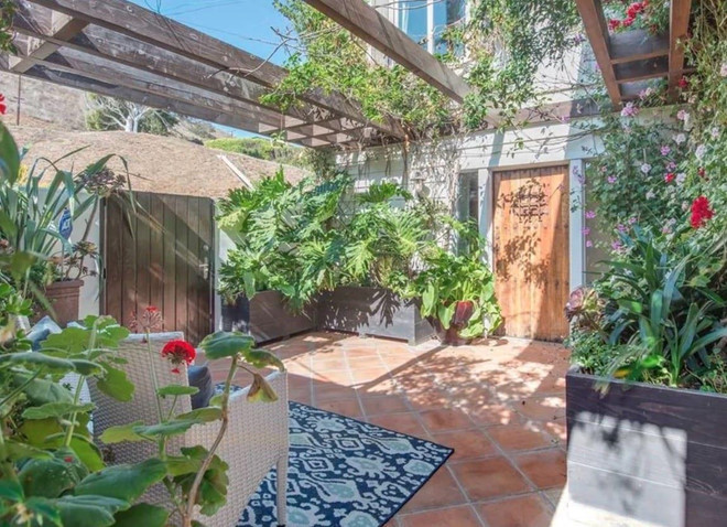 Sân vườn nhỏ xinh với giàn nho và đầy cây xanh, cung cấp một khoảng không gian yên bình cho căn biệt thự.