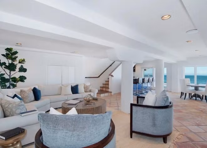 Khu vực giải trí với nhiều bộ sofa khác nhau và một quầy bar thu nhỏ nằm trong góc phòng. Từ căn phòng này, gia chủ cũng dễ dàng bước ra ngoài và tản bộ dọc bờ biển.