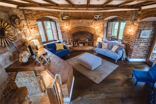 Phía bên trong phòng khách được thiết kế ấm cúng với gỗ sồi và đèn vàng.