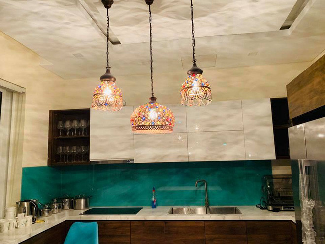 Một góc phòng bếp với tone màu xanh nhã nhặn với điểm nhấn là chùm đèn sang trọng, quý phái.