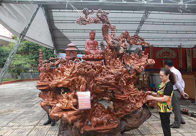 Đầu tiên là tác phẩm có tên Thập Bát La Hán, anh Trần Ngọc Biển (Thái Nguyên), chủ nhân của ba tác phẩm cho biết, 80% tác phẩm này được làm từ một gốc cây nu hương đỏ Gia Lai, rất quý hiếm. Hiện, tác phẩm được chào bán với giá 1,2 tỷ đồng.